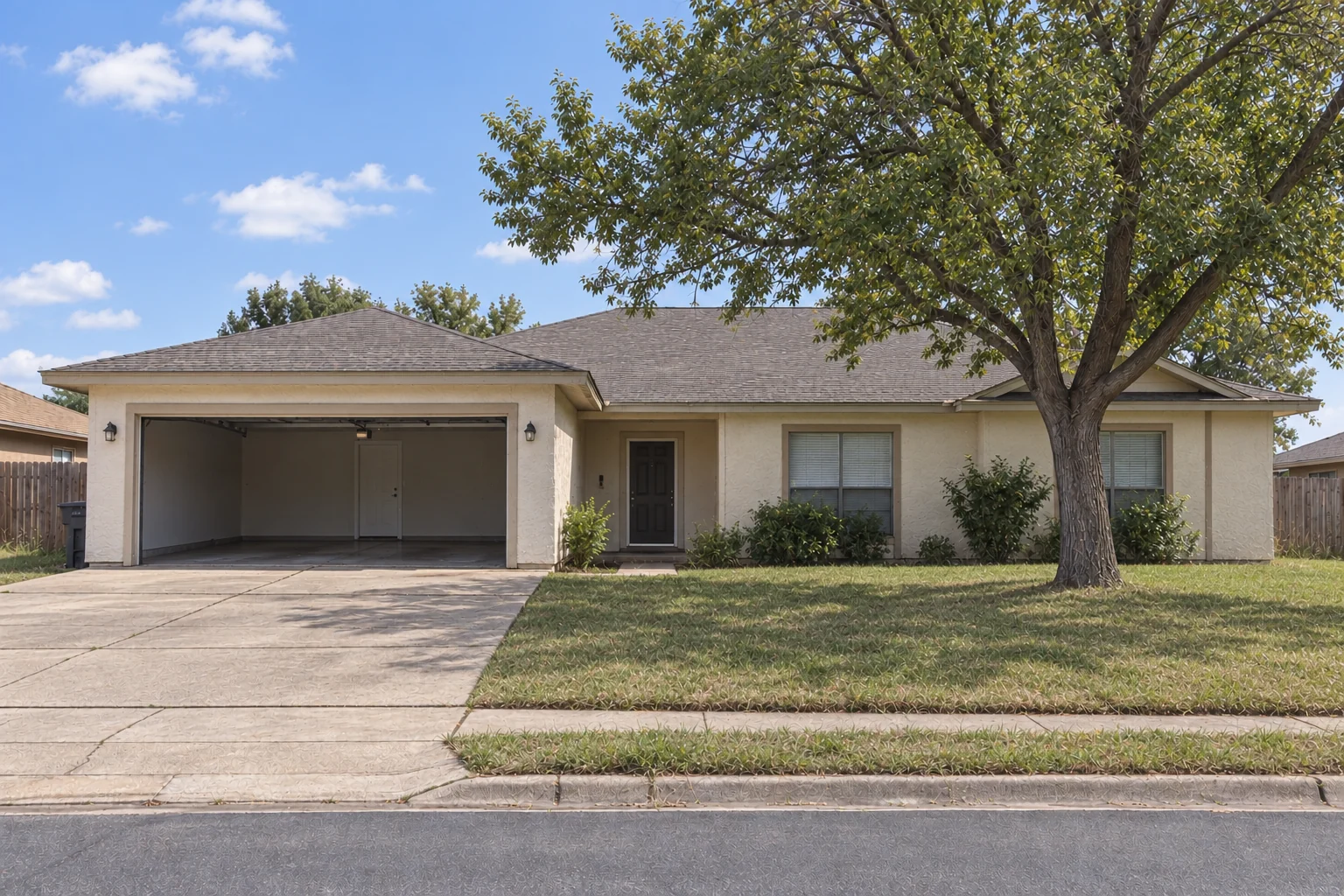 After: The same home with a trimmed lawn, refreshed exterior, clear driveway, and an empty garage
